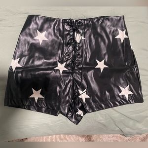 Black faux leather shorts with white stars